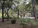 View of a building nestled in a lush landscape of mature trees and greenery at 415 Ocean Creek Dr. # 2117, Myrtle Beach, SC 29572