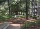 Lush landscaping with trees, shrubs, mulch, and a sidewalk with bench seating near the building at 415 Ocean Creek Dr. # 2117, Myrtle Beach, SC 29572