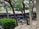 Charming outdoor patio area with tables and umbrellas, surrounded by lush trees and greenery at 415 Ocean Creek Dr. # 2117, Myrtle Beach, SC 29572