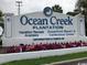 Prominent Ocean Creek Plantation sign with vibrant flowers, welcoming visitors for vacation rentals at 415 Ocean Creek Dr. # 2117, Myrtle Beach, SC 29572