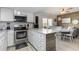 Modern kitchen features a breakfast bar with seating and stainless-steel appliances overlooking the dining room at 4307 Beverly Ct., North Myrtle Beach, SC 29582