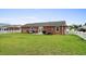 Expansive backyard with well-maintained lawn, patio with seating, and a classic brick home exterior at 4639 Mandi Ave., Little River, SC 29566