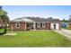 Charming brick home with a well-manicured lawn, front porch seating, and inviting curb appeal at 4639 Mandi Ave., Little River, SC 29566