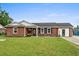 Charming brick home featuring a well-manicured lawn, classic shutters, and a welcoming front entrance with cozy chairs at 4639 Mandi Ave., Little River, SC 29566