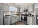 Bright kitchen with stainless steel appliances, grey cabinets and a window view at 4639 Mandi Ave., Little River, SC 29566