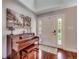 Inviting entryway with gleaming hardwood floors, and elegant piano next to the white front door with sidelights at 5113 Pee Dee Ln., Murrells Inlet, SC 29576