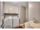 Functional laundry room with a washer, dryer, utility sink, and built-in cabinets for storage at 5113 Pee Dee Ln., Murrells Inlet, SC 29576