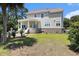 Backyard featuring a house with a rounded patio and staircase, combined with a grassy lawn at 5460 Huntington Marsh Rd., Murrells Inlet, SC 29576