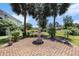 Backyard patio with a stone fountain, framed by palm trees and lush greenery, perfect for relaxing at 5460 Huntington Marsh Rd., Murrells Inlet, SC 29576