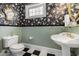 Elegant bathroom features a pedestal sink, decorative mirror, and black-and-white tile flooring at 5460 Huntington Marsh Rd., Murrells Inlet, SC 29576