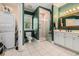 A well-lit bathroom with a glass-enclosed shower, toilet and vanity with a washer and dryer nearby at 5460 Huntington Marsh Rd., Murrells Inlet, SC 29576