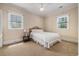 Bedroom with neutral walls, two windows, and a bed with a side table, creating a simple retreat at 5460 Huntington Marsh Rd., Murrells Inlet, SC 29576