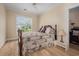 Cozy bedroom featuring a floral patterned bed, a ceiling fan, and natural light from the window at 5460 Huntington Marsh Rd., Murrells Inlet, SC 29576