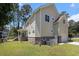 Back of home with yellow siding and a brick foundation, garage, patio and fenced-in A/C units at 5460 Huntington Marsh Rd., Murrells Inlet, SC 29576