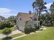 Beautiful two-story home with a well-manicured lawn, attached garage, and charming architectural details at 5460 Huntington Marsh Rd., Murrells Inlet, SC 29576