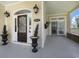 Inviting front porch with decorative planters and a stained wood front door at 5460 Huntington Marsh Rd., Murrells Inlet, SC 29576