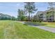 Well-maintained lawn alongside a paved path and residential buildings in the background at 5852 Longwood Dr. # 302, Murrells Inlet, SC 29576