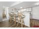 Eat-in kitchen features three bamboo bar stools at a white counter with wooden floor and white cabinetry at 5905 South Kings Hwy. # 5202, Myrtle Beach, SC 29575