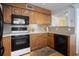 Well-lit kitchen with wooden cabinets, black appliances, and a view into the hallway at 5905 South Kings Hwy. # A518, Myrtle Beach, SC 29575