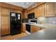 Cozy kitchen featuring wood cabinets, black appliances, and neutral countertops at 5905 South Kings Hwy. # A518, Myrtle Beach, SC 29575