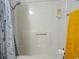 Clean bathroom with a shower-tub combination and a yellow towel, complemented by a stylish and functional design at 6001 S Kings Hwy., Myrtle Beach, SC 29575