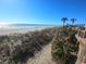 Scenic beach view with soft sand, ocean waves, and a clear blue sky, perfect for relaxation and recreation at 6001 S Kings Hwy., Myrtle Beach, SC 29575