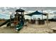 Outdoor playground equipment with slides, climbing structures and a picnic table on a sandy surface at 6001 S Kings Hwy., Myrtle Beach, SC 29575