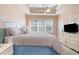 A bedroom featuring a tray ceiling, a dresser with a TV, and lots of natural light at 6015 Catalina Dr. # 134, North Myrtle Beach, SC 29582