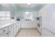 The bright kitchen offers white cabinets, tile flooring, and a view from the breakfast bar at 6015 Catalina Dr. # 134, North Myrtle Beach, SC 29582