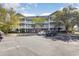 Condo building exterior shows ample parking and multiple balconies overlooking landscaped grounds at 6015 Catalina Dr. # 134, North Myrtle Beach, SC 29582
