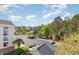 Aerial view of parking lot with fountain, landscaping, and building with screened-in porches at 6015 Catalina Dr. # 134, North Myrtle Beach, SC 29582