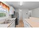 Updated kitchen with white cabinets, stainless appliances, and a view into an adjacent room at 6500 Colonial Dr. # 2, Myrtle Beach, SC 29572