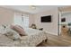 Bedroom featuring hardwood floors, large bed, and mounted flat screen TV at 6630 W Sweetbriar Trail, Myrtle Beach, SC 29588