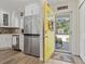 Bright entryway featuring a yellow door, adjacent to a modern kitchen with stainless steel appliances at 6630 W Sweetbriar Trail, Myrtle Beach, SC 29588
