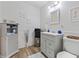 Well-lit half bath with coastal decor, gray vanity, and wood-style flooring at 6630 W Sweetbriar Trail, Myrtle Beach, SC 29588