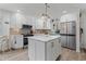 Modern white kitchen with a center island, stainless steel appliances, and stylish pendant lighting at 6630 W Sweetbriar Trail, Myrtle Beach, SC 29588