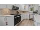Bright kitchen with white cabinets, stainless steel appliances, and elegant backsplash at 6630 W Sweetbriar Trail, Myrtle Beach, SC 29588