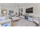 Bright living room with fireplace, TV, and sliding glass doors to lanai at 6630 W Sweetbriar Trail, Myrtle Beach, SC 29588