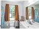Functional bathroom with a white vanity, toilet, large mirror, and window with private wooded view at 67 Bossie Ln., Georgetown, SC 29440