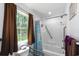 Bright bathroom features a walk-in shower with safety grab bars and a window providing natural light at 67 Bossie Ln., Georgetown, SC 29440