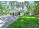 Beautiful single story home nestled among the trees featuring a large front yard and gravel driveway at 67 Bossie Ln., Georgetown, SC 29440