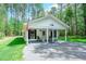 Charming single story house with a covered front porch and gravel driveway surrounded by lush trees at 67 Bossie Ln., Georgetown, SC 29440