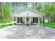 Charming single story house with a covered front porch and gravel driveway surrounded by lush trees at 67 Bossie Ln., Georgetown, SC 29440