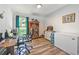 Bright office with wood floors, desk, display cabinet, and a large window overlooking lush greenery at 67 Bossie Ln., Georgetown, SC 29440