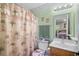 Cozy bathroom features a palm-themed shower curtain, towels, and a view into the primary bedroom at 739 Tall Oaks Dr., Myrtle Beach, SC 29588