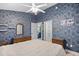 Spacious bedroom featuring blue accent wall, multiple doors, and matching dressers at 739 Tall Oaks Dr., Myrtle Beach, SC 29588
