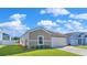 Exterior of a one-story home featuring a driveway, front lawn, and lush greenery, with light blue siding at 796 Wapama St., Little River, SC 29566