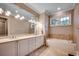 Bathroom features double sink vanity, soaking tub, and large mirror with decorative lighting at 9 Winnowing Way, Pawleys Island, SC 29585
