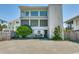 A charming three-story home exterior featuring large windows, and a well-maintained yard at 9 Winnowing Way, Pawleys Island, SC 29585