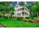 Elegant two-story home with a charming front porch, manicured lawn, and mature landscaping, showcasing curb appeal at 9 Winnowing Way, Pawleys Island, SC 29585